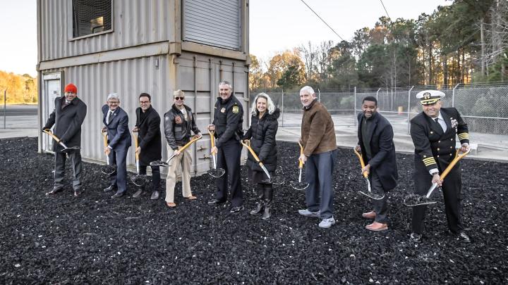 9 people standing with shovels